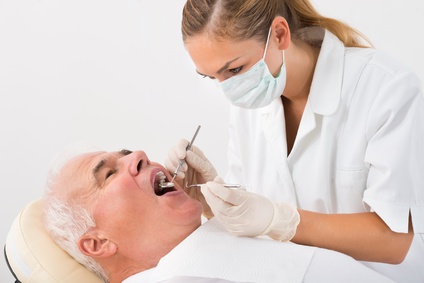 Homme qui se fait soigner une dent chez son dentiste